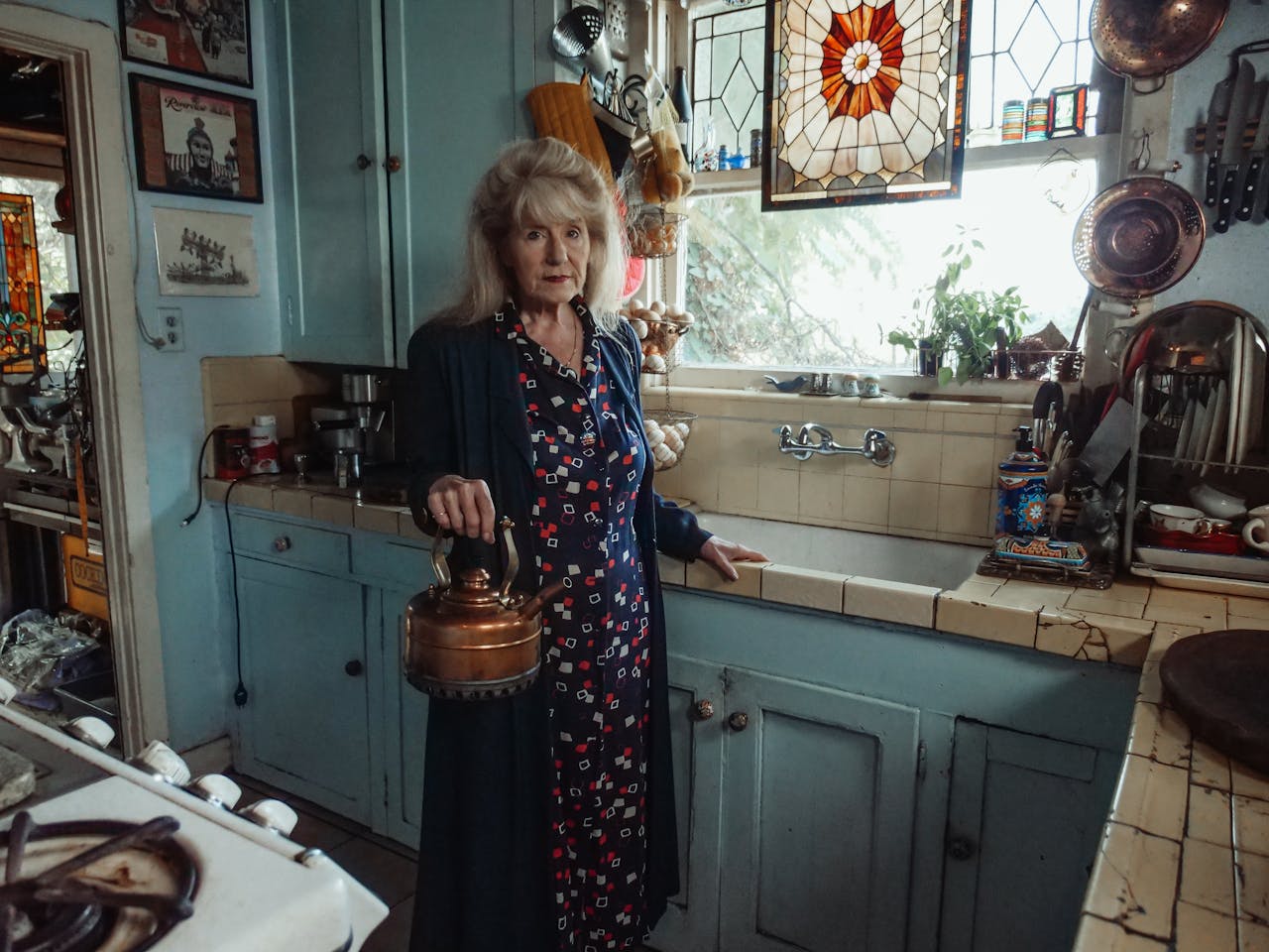 Woman holding kettle in old farm kitchen