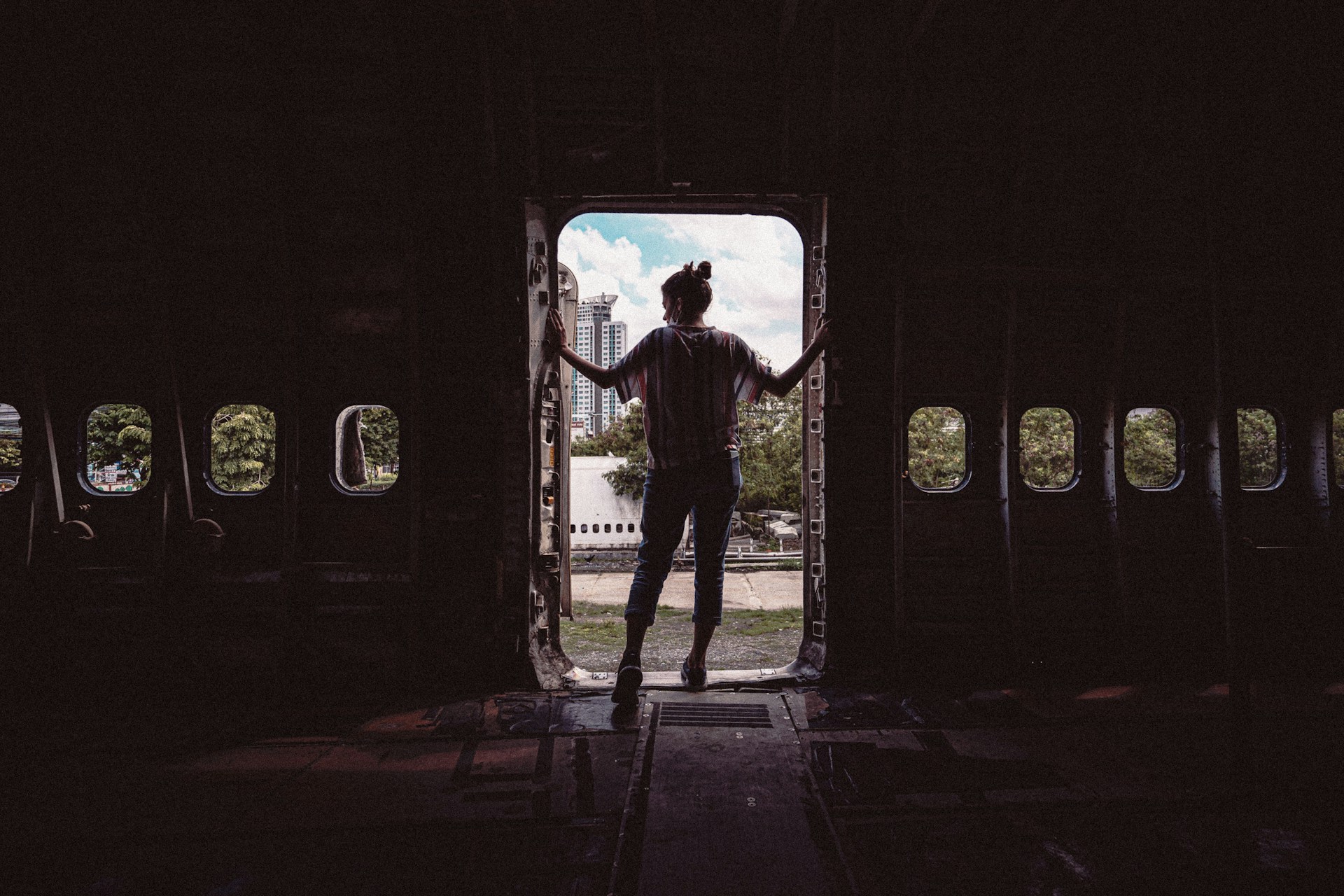 Individual standing in the doorway of an abandoned airplane