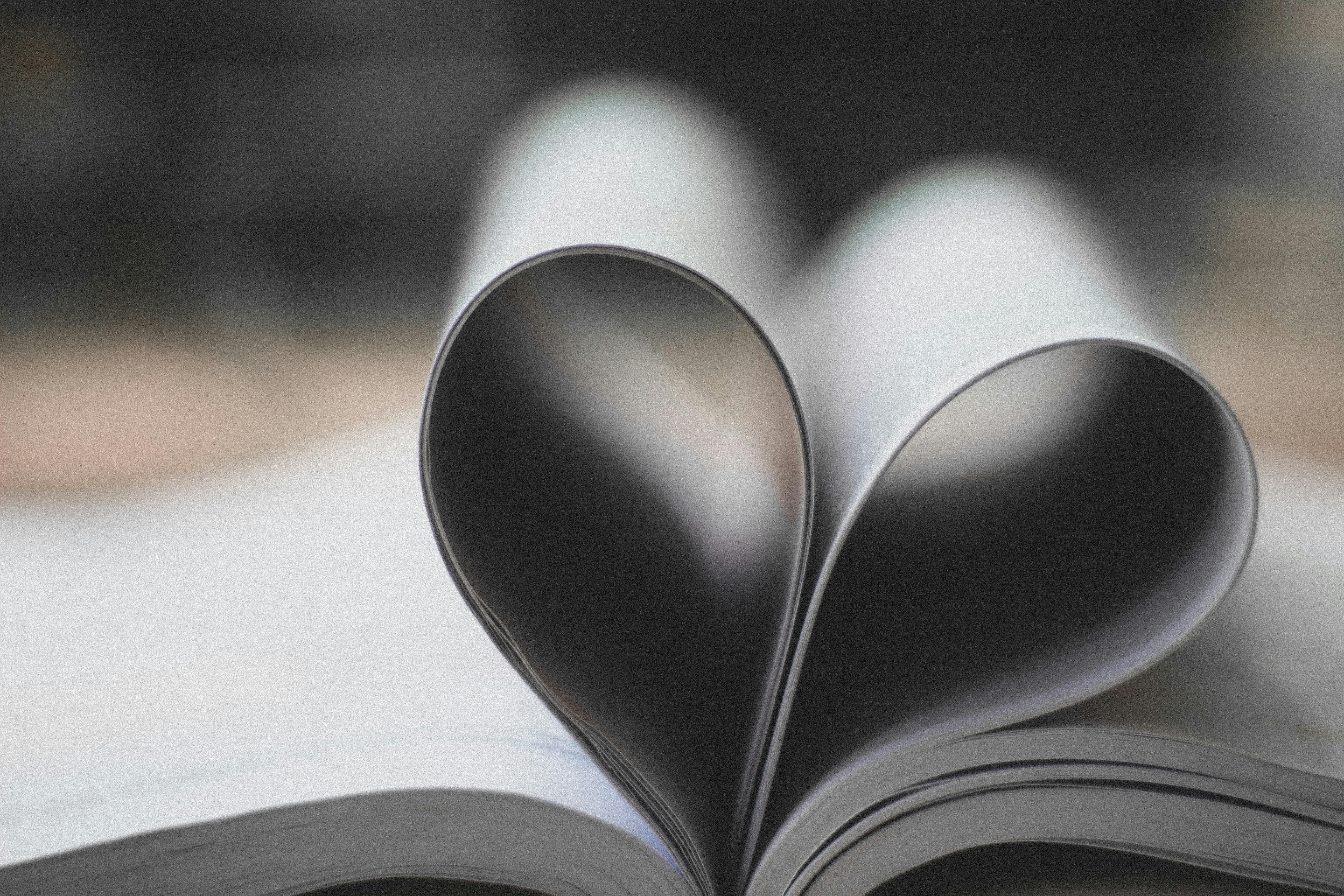 A book lying open on a flat surface, some of the pages folded into a heart