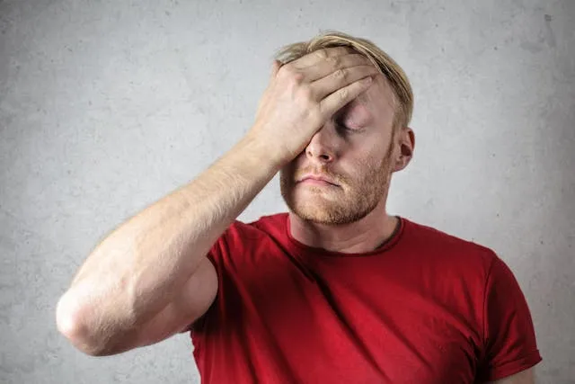 Man covering face in dissapointment